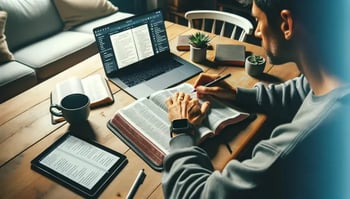 A man studying the Bible with books and technology.